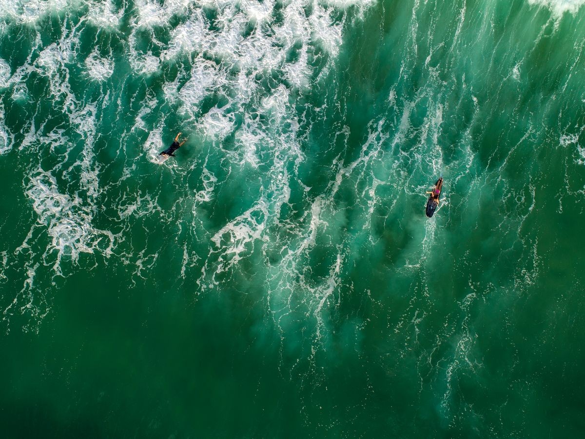 
View from the drone as surfers ride on the coast of the Mediterranean Sea, the city of Herzliya, Israel.
